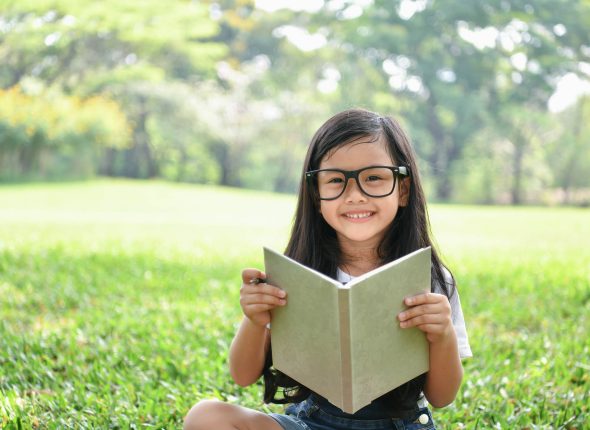 Education Concepts. The girl is reading a book in the garden. Be